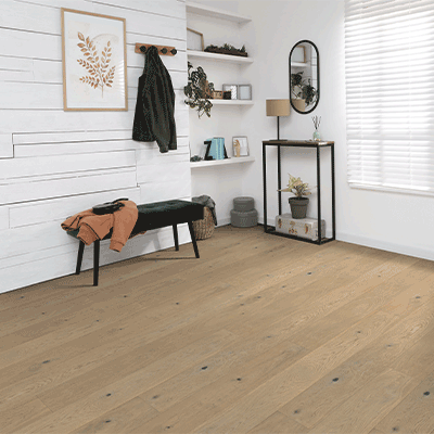 warm toned hardwood flooring in entryway with storage